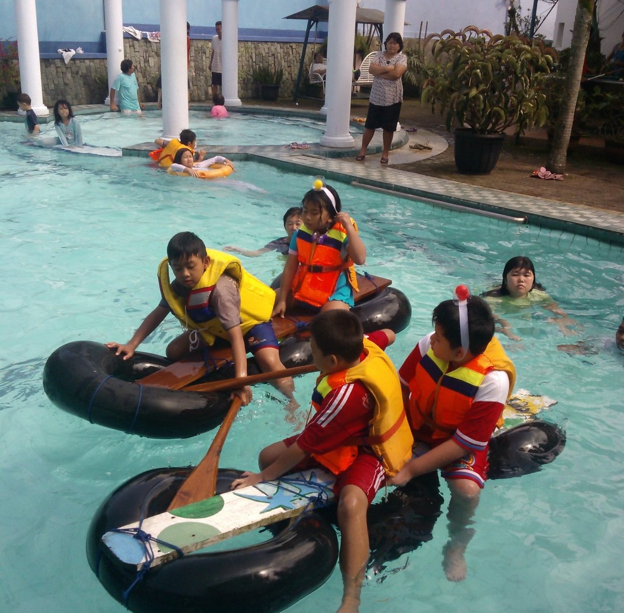 Anak-anak bekerja sama mengendalikan rakit sederhana saat mengikuti water games keluarga di Villa Giri Kembang Cipanas.